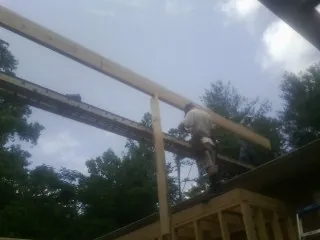 Carpenter setting a ridge beam over a new addition frame — Ice Dam Removal by Roofing Brothers in Cecil